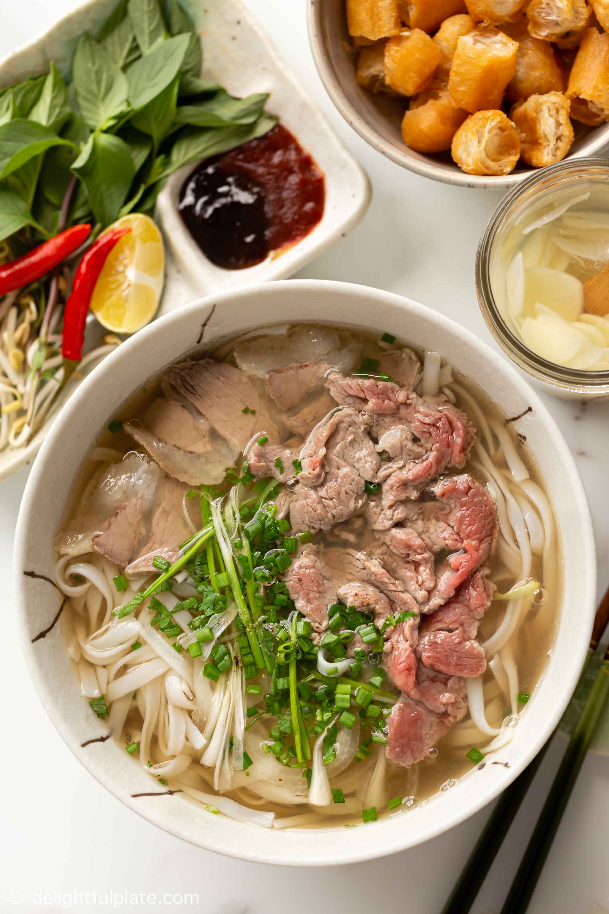 一碗越南河粉汤面，上面有熟透的牛肉和半熟的牛肉。gydF4y2Ba